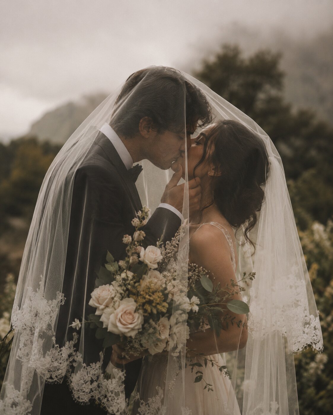 Bride and groom sharing an intimate moment beneath a veil